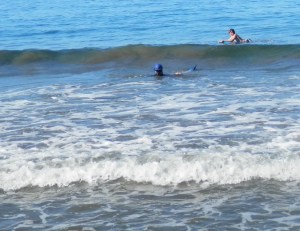 Kathleen trying to get the fins off in the surf