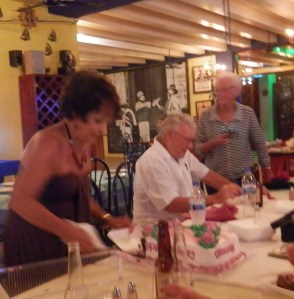Christine cutting her cake with the /Senor in the back ground